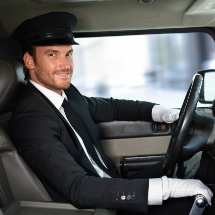 Limousine driver wearing his Limo Beirut formal uniform with his left hand on the steering wheel and right hand on the gear