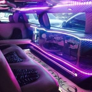 Limousine interior with special led lighting system and bar equipped with champagne glasses