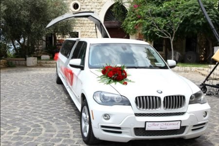 Stretch limousine BMW X5 with red roses wedding decoration