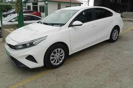 Whtie Kia Cerato parked in a large parking lot of Limo Beirut