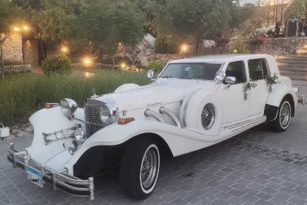 The front of the vintage Excalibur car with wedding flower decoration