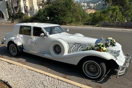 White vintage Excalibur car parked in a luxury residential area in Lebanon
