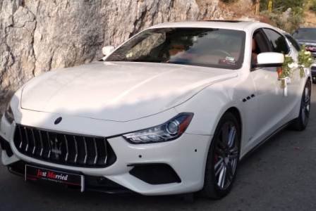 Maserati Ghibli white color with flower decoration moving forward in a wedding convoy in Lebanon