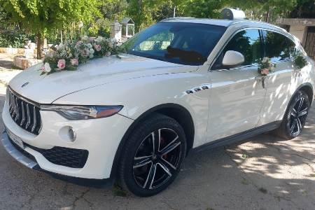 Maserati Levante decorated in colorful flowers and parked in a green garden