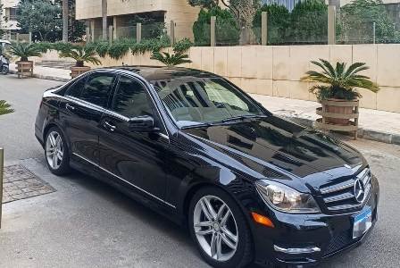 Luxury Taxi Black Mercedes C Class next to a beautiful palm tree