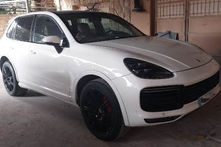 Luxury Taxi Porsche Cayenne parked in parking lot of  residential area